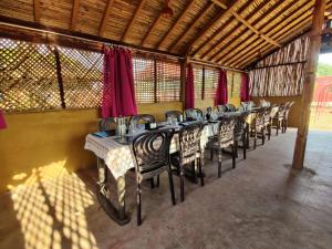 a row of tables in a restaurant with red curtains at Santkrupa Villa Resort in Nakhtarāna
