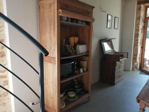- armadio in legno con forno a microonde in camera di Les chambres de balade au jardin a Épineu-le-Chevreuil