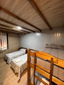 two beds in a room with wooden ceilings at Alojamiento cerro d la salina in Ronda