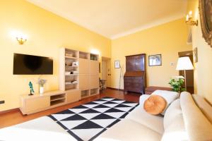 een woonkamer met een bank en een tv bij Residenza alla Cattedrale in Center Town in Lucca