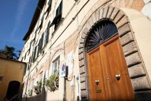 een houten deur aan de zijkant van een gebouw bij Residenza alla Cattedrale in Center Town in Lucca