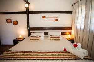 a bedroom with a large bed with white sheets and pillows at Pousada Santu Noronha in Fernando de Noronha