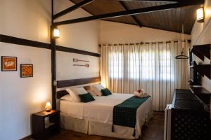 a bedroom with a bed and a large window at Pousada Santú Noronha in Fernando de Noronha