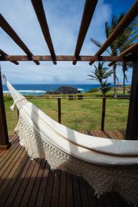 a hammock on a deck with a view of the ocean at Pousada Santu Noronha in Fernando de Noronha