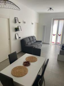 a living room with a table and a couch at Deluxe Apartment Self Check in Parking in Genova