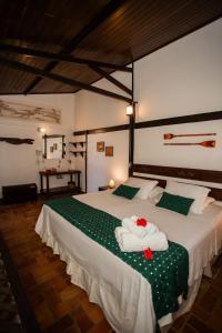 a bedroom with a large bed with towels on it at Pousada Santu Noronha in Fernando de Noronha