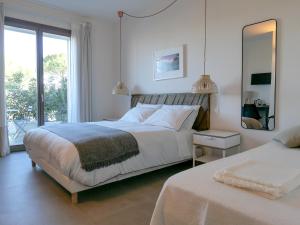 a white bedroom with a bed and a mirror at B&B Ramerino in Grosseto