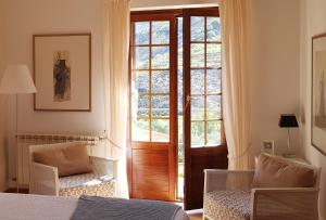 1 dormitorio con una puerta que conduce a una ventana en La Almunia del Valle, en Monachil