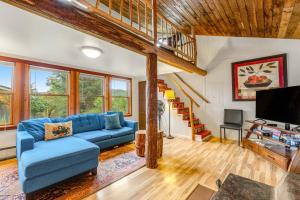 a living room with a blue couch and a tv at Seabeck House & Cottage on Hood Canal in Seabeck