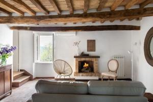 ein Wohnzimmer mit einem Sofa und einem Kamin in der Unterkunft Il Borghetto - La Casa di Elba, Terrazzo panoramico in Val d'Orcia in Castelnuovo dellʼAbate