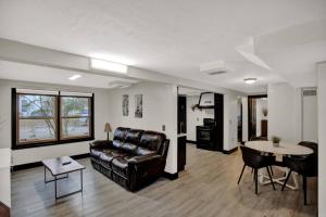 a living room with a leather couch and a table at Unique Downtown 2br 2ba close to everything Apt.B in Gainesville