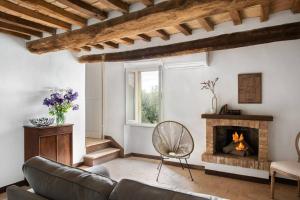 ein Wohnzimmer mit einem Sofa und einem Kamin in der Unterkunft Il Borghetto - La Casa di Elba, Terrazzo panoramico in Val d'Orcia in Castelnuovo dellʼAbate