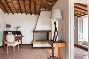 ein Wohnzimmer mit einem Schreibtisch und einem Tisch mit einer Lampe in der Unterkunft Il Borghetto - La Casa di Elba, Terrazzo panoramico in Val d'Orcia in Castelnuovo dellʼAbate