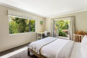 - une chambre avec un lit et une grande fenêtre dans l'établissement Ultimate 5-Bedroom Rural Poolside Oasis - Auckland, à Albany