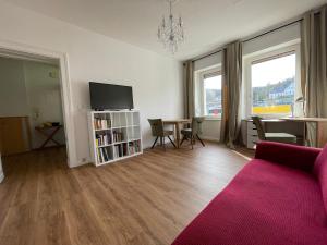 a living room with a couch and a tv and a table at Wohnen am Wanderbahnhof Iserlohn in Iserlohn
