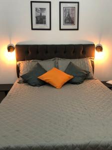 a bed with an orange pillow and pillows on it at Studio Próx 25 de Março, República , José Paulino. in Sao Paulo