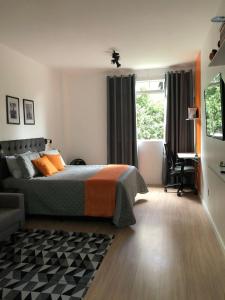 a bedroom with a bed and a desk and a window at Studio Próx 25 de Março, República , José Paulino. in Sao Paulo