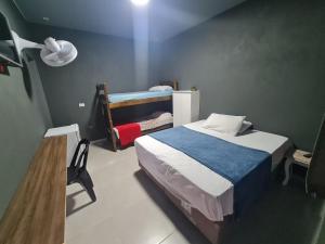 Pousada D’San Shower & Bed في فينهيدو: غرفة نوم مع سرير وسرير بطابقين