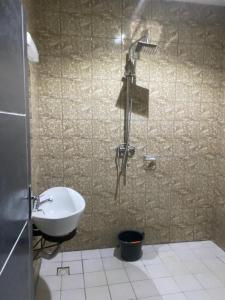 a bathroom with a shower with a sink and a sink at Sunrise Center Bonapriso - 107 in Douala +3 photos