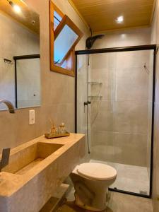 a bathroom with a shower and a toilet and a sink at Chalé com hidro e vista (insta @altodamontanhars) in Bento Gonçalves