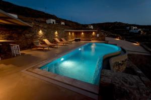 a swimming pool in a backyard at night at Alos Residence in Agios Romanos