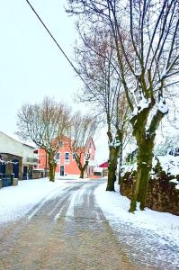 a snow covered street with trees and buildings at Villa Tauria- Casa de campo em aldeia medieval in Sabugal