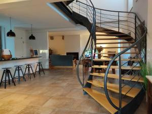 a spiral staircase in a living room with a bar at Villa Tauria- Casa de campo em aldeia medieval in Sabugal