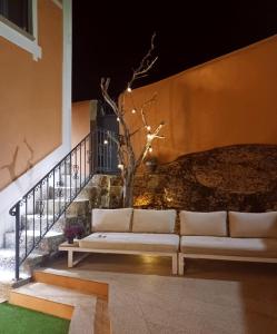 a white couch sitting on the side of a building at Villa Tauria- Casa de campo em aldeia medieval in Sabugal