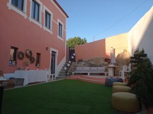 a courtyard of a house with a green lawn at Villa Tauria- Casa de campo em aldeia medieval in Sabugal