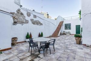 a patio with a table and chairs and a staircase at Can Mateuet - House Rental by Season in Llagostera
