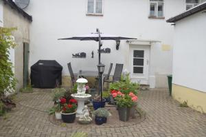 un patio con plantas y una sombrilla frente a un edificio en Ferienhaus Erika, en Geringswalde