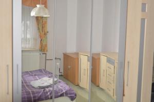 Habitación con cama, armarios y espejo. en Ferienhaus Erika, en Geringswalde