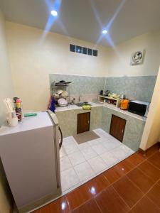 uma cozinha com um frigorífico no meio de um quarto em สวนสน โฮมสเตย์ em Mae Hong Son