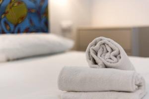 a pile of towels sitting on top of a bed at Grand T2 avec balcon • proche parc de la Tête d'Or in Caluire-et-Cuire