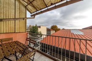 balkon z ławką i czerwonym dachem w obiekcie Grand T2 avec balcon • proche parc de la Tête d'Or w mieście Caluire-et-Cuire