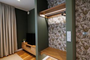 a living room with green walls and a television at B85 Suites in Warsaw