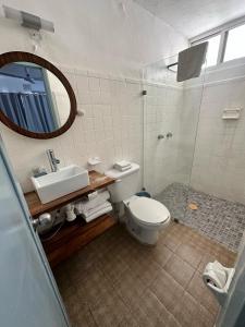 La salle de bains est pourvue de toilettes, d'un lavabo et d'un miroir. dans l'établissement Creta Hotel & Suites, à Mazatlán