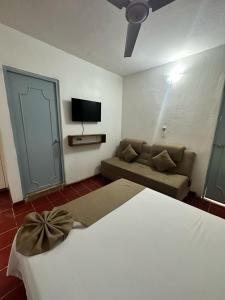 Habitación de hotel con cama y sofá en Creta Hotel & Suites, en Mazatlán