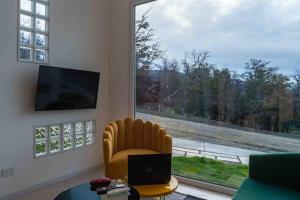 sala de estar con silla y ventana grande en Miradores del Susana Duplex III en Ushuaia