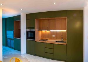 a large kitchen with green cabinets and a sink at Miradores del Susana Duplex III in Ushuaia