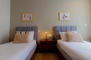 dos camas sentadas una al lado de la otra en un dormitorio en Capitalia - Apartments - Downtown del Valle en Ciudad de México