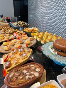 uma mesa com vários tipos diferentes de alimentos em Pousada Villa Alferes em Tiradentes