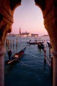 un grupo de barcos en el agua con una ciudad en el fondo en Venice Lion Residence - Vespucci en Mestre