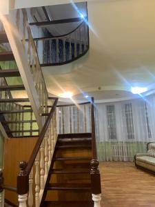 eine Treppe in einem Haus mit Lichtern an der Decke in der Unterkunft Laola民宿 in Almaty