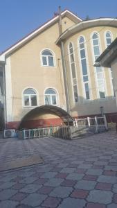 ein großes Gebäude mit einer Garage davor in der Unterkunft Laola民宿 in Almaty
