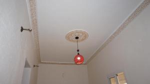 a red light bulb hanging from a ceiling at Jinane in Meknès