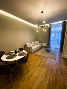 ein Wohnzimmer mit einem Sofa, einem Tisch und Stühlen in der Unterkunft CITY CENTER 2, Cozy and Modern 2br in the city center in Budapest