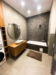 ein Badezimmer mit einer Badewanne, einem Waschbecken und einem Spiegel in der Unterkunft CITY CENTER 2, Cozy and Modern 2br in the city center in Budapest