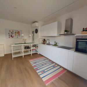 una cocina con armarios blancos y una alfombra en el suelo en La casa di Matías, en Valverde