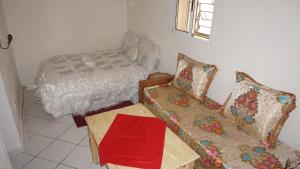 a living room with a couch and a bed at Jinane in Meknès